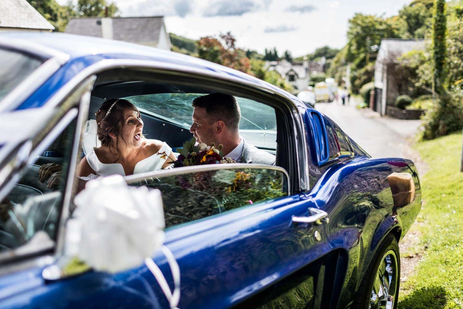Bride and groom drive away in Ford Mustang at a South Wales wedding 