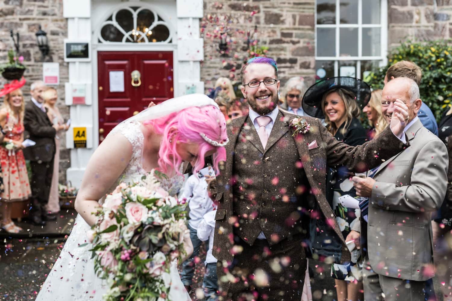 Bride with pink hair and groom with multi coloured hair getting married at Peterstone Court