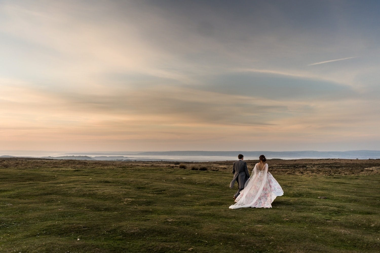 Bride and groom at the King Arthur Stone in Gower, South Wales on their wedding day