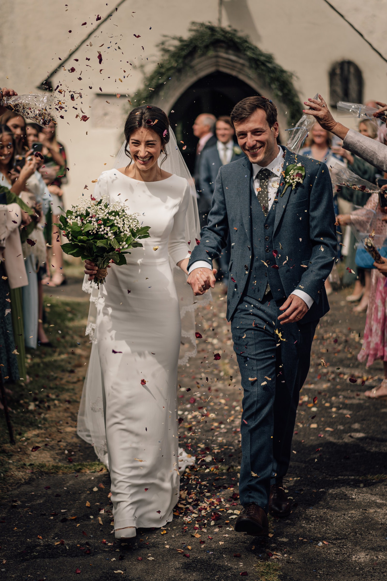 bride and groom walking in confetti