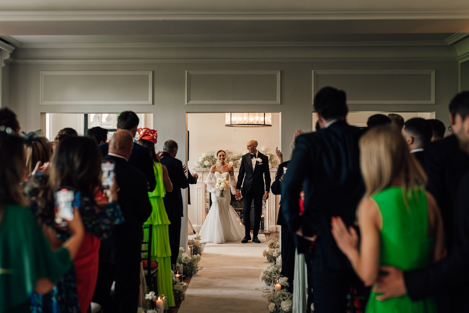 bride and groom walk down aisle at Sant Ffraed House
