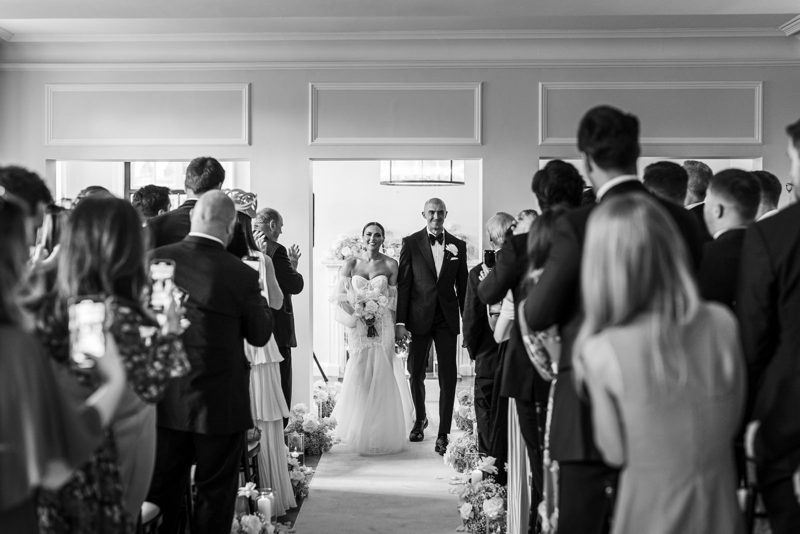 bride and groom walk down aisle at Sant Ffraed House
