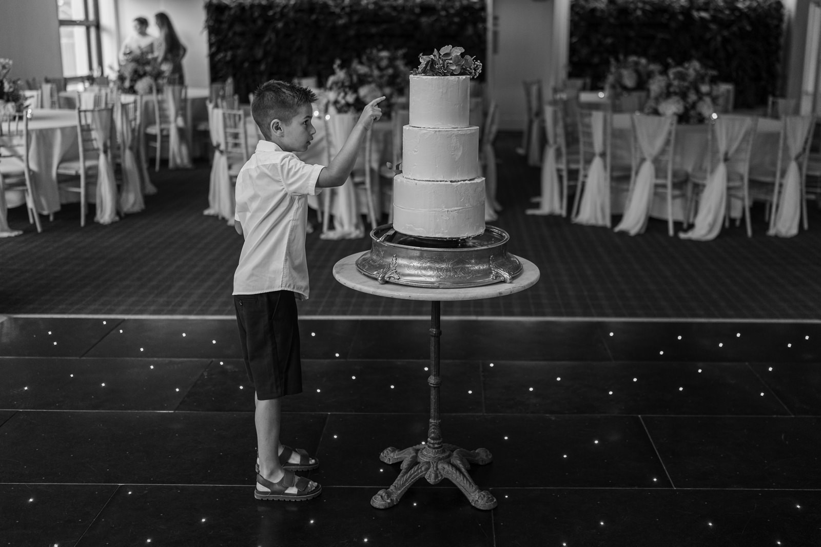 Boy pokes wedding cake